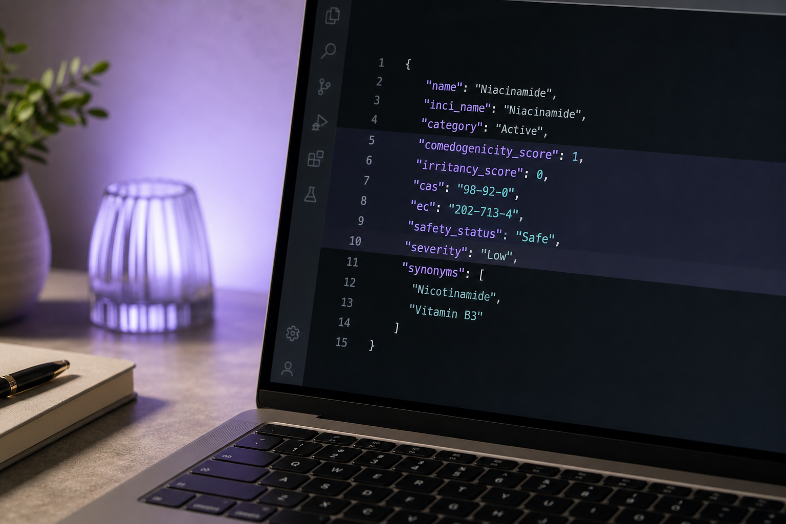 Laptop screen close-up showing a JSON response in a dark-theme code editor (VS Code style). Visible fields include comedogenicity_score, irritancy_score, cas, safety_status, severity. Slight blur on the surrounding desk surface, sharp focus on the hi