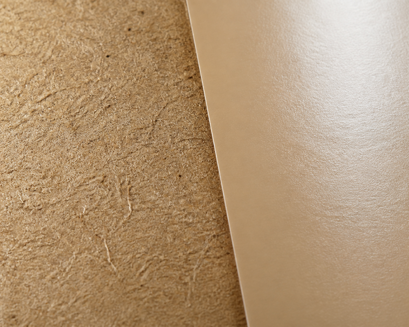 Macro close-up split frame — left half shows raw brown kraft fiber texture (visible fibrous grain), right half shows a smooth coated/glossy paper surface — even lighting, extreme detail to reveal the fiber difference.